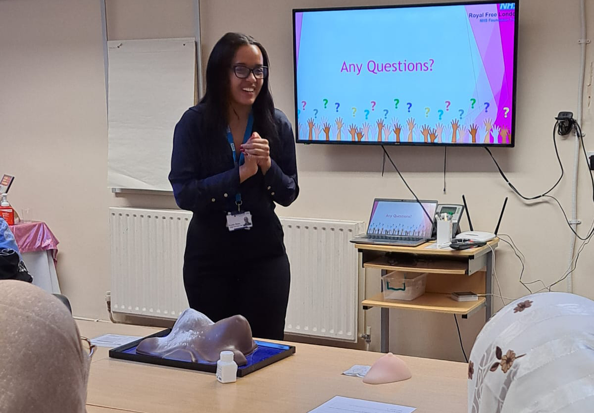 A member of the Health Promotion Team with a model of a breast