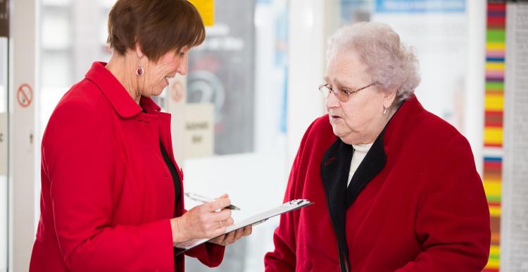 elderly woman in conversation with another woman