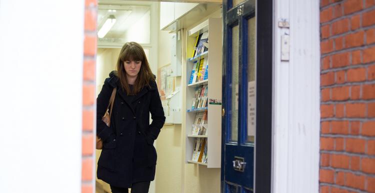 woman walking through the entrance of a GP surgery