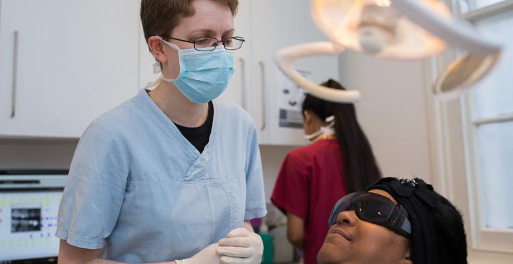 A dentist wearing a blue face mask