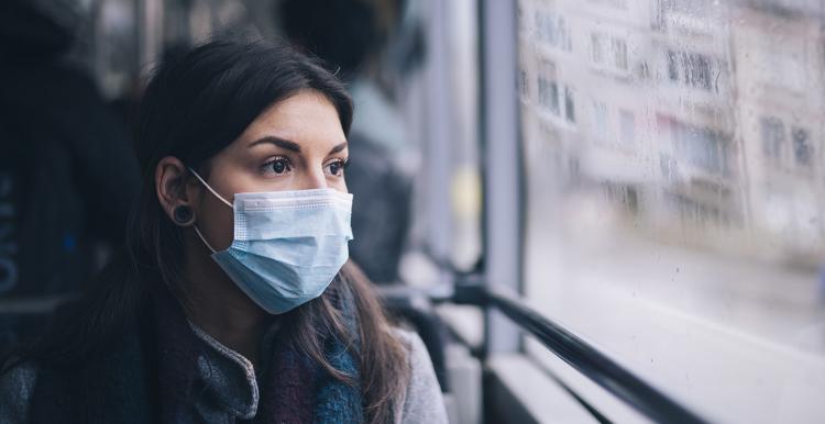 Woman on a bus in a facemask