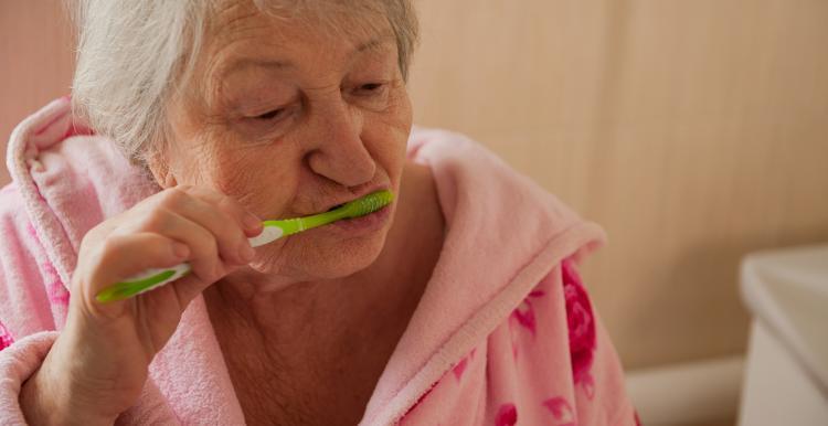 Elderly woman brushing her teeth