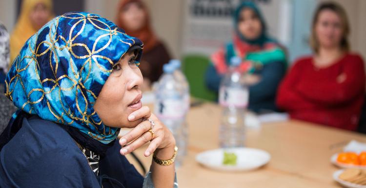 A woman in a headscarf listening 