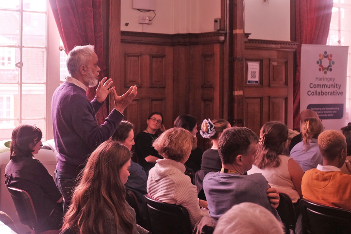 Asian man making a point about health inequality at a meeting in Islington Town  Hall