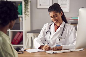 Female doctor in white coat having meeting with woman