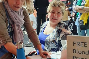 Healthwatch staff giving a blood pressure reading to Emily Thornberry at the Cally Festival in July 2023.
