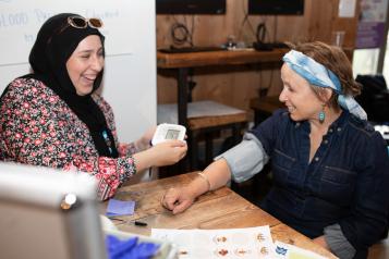 Laughing women measuring blood pressure