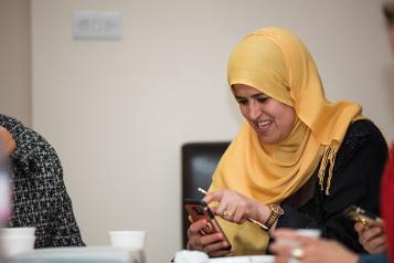 Woman in head scarf learning about her smartphone at a digital inclusion event