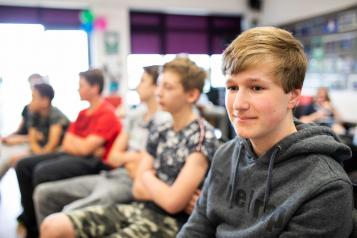 Thoughtful teenage boy in a group setting