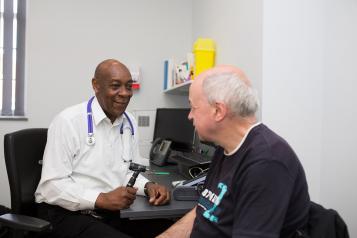 GP holding ear inspection device with patient