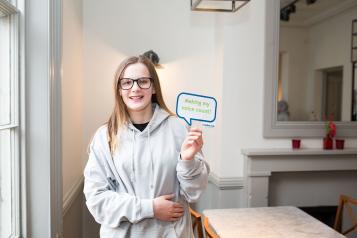 Teenage girl holding sign with the words 'Making my voice count'