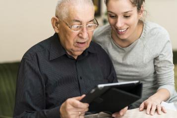 Older man and younger woman looking at a tablet