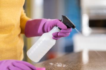 Person wearing protective gloves cleaning a surface