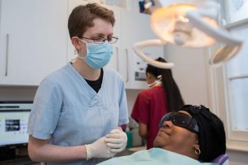 A dentist wearing a blue face mask