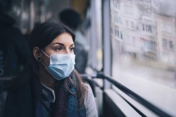 Woman on a bus in a facemask