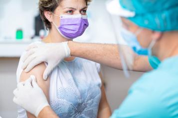 Woman in a facemask preparing for a vaccination