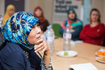 A woman in a headscarf listening 