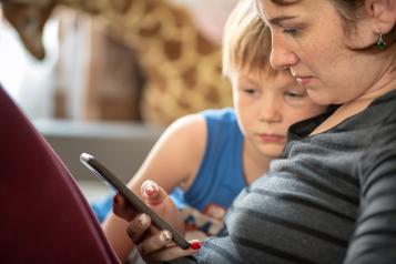 Mother and son setting parental controls on a smartphone