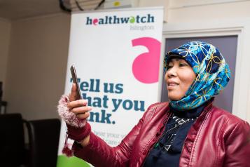 Woman wearing a headscarf looking at her phone