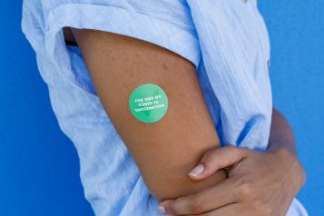 Person's arm has a sticker saying 'I've had my COVID-19 vaccination