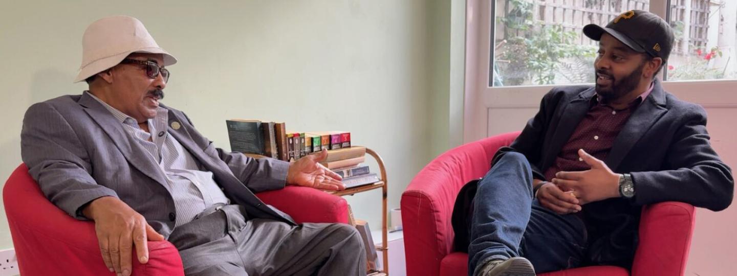 Two Back men siiting in chairs. They are Prostate Buddies