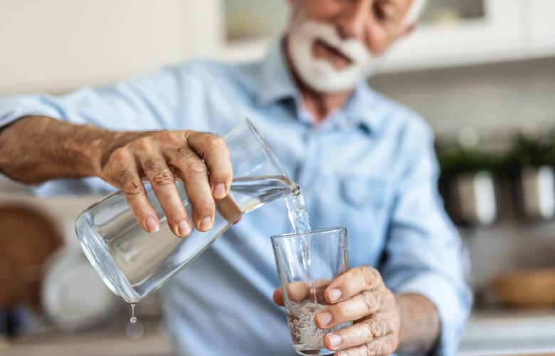 Man pouring water from cask into glass