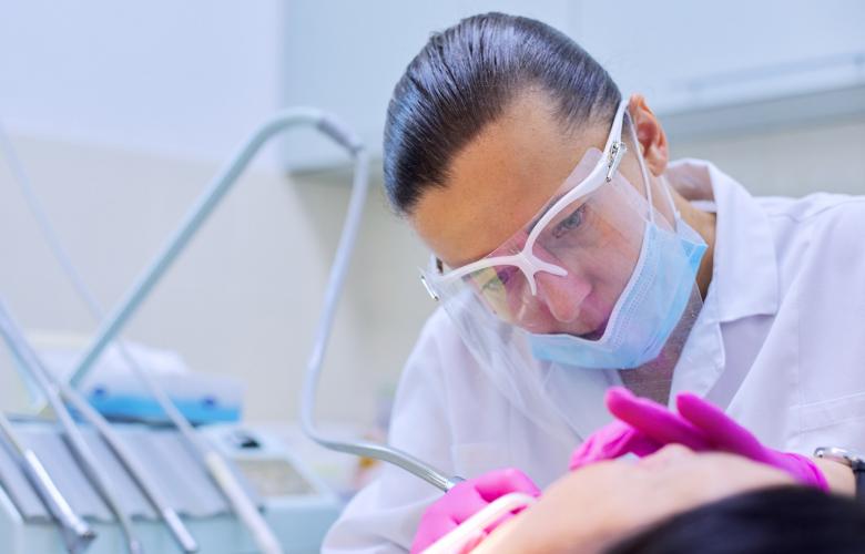 Experienced dentist treats teeth in patient