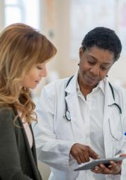 woman in exam room looking at results with doctor